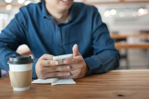 Asian man using phone in coffee shop Stock Photos