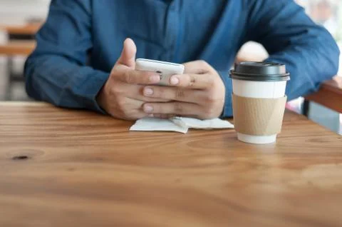 Asian man using phone in coffee shop Stock Photos