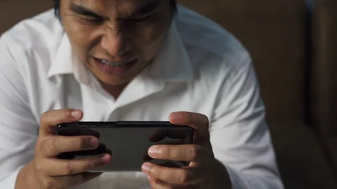 Asian man using smart phone for play the game for relax Stock Footage 121103941