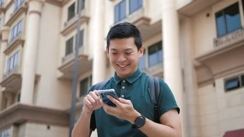 Asian man using smart phone in the street urban with building background Видео 156439466