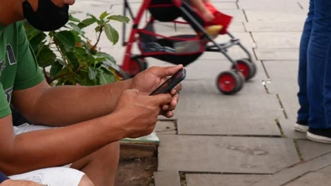 Asian man using a smartphone for checking message in public space Stock Footage 246902100