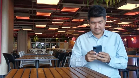 Asian man using smartphone gadget social media mobile application Stock Footage 296640752
