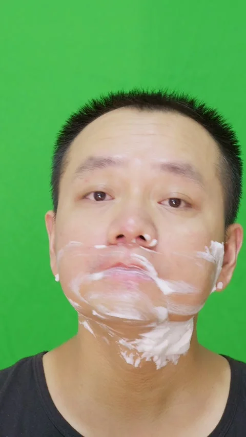 Asian man using wet wipes to clean white shaving cream on his face after shaving Stock Footage 315418229