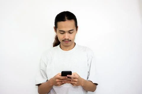Asian man with various expressions while holding mobile phone. Stock Photos