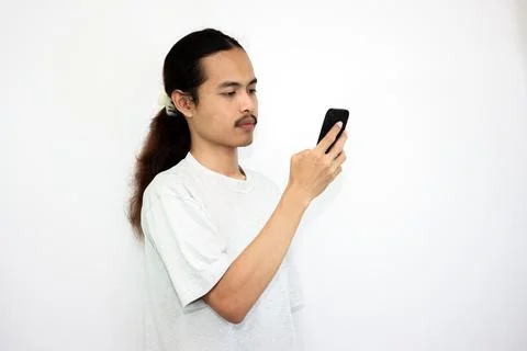Asian man with various expressions while holding mobile phone. Stock Photos