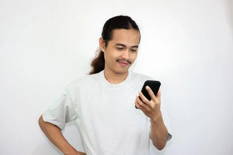 Asian man with various expressions while holding mobile phone. Stock Photos