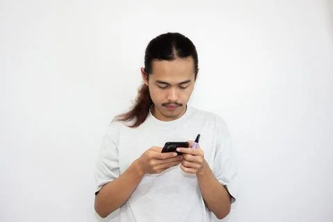 Asian man with various expressions while holding mobile phone. Stock Photos