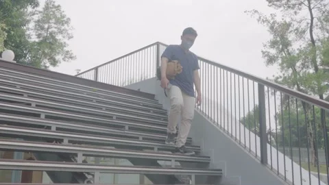 An asian man is walking down the stairs of the literacy park Stock Footage 221872994