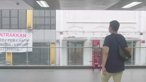 An asian man is walking towards the end of the barrier on the second floor. Stock Footage 222033337