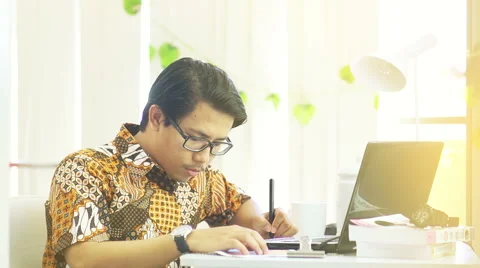 Asian Man Wearing Batik Working at Office - Slow Motion Stock Footage 60618158