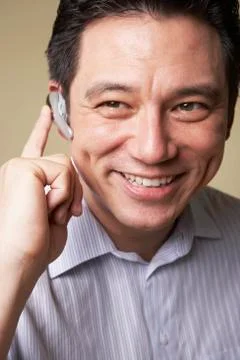 Asian man wearing hands free device Stock Photos