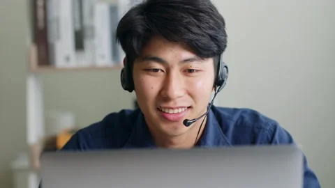 Asian man wearing headset talking on video call conference or virtual meeting Stock Footage 196919149
