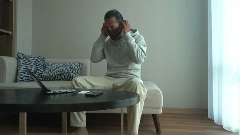 Asian man wearing mask while working from home. using laptop in the living room 스톡 동영상 226948061