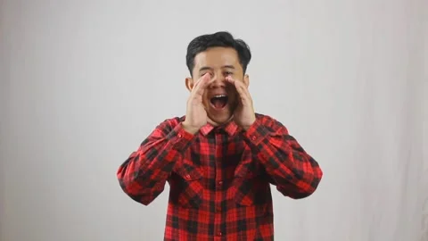 Asian man wearing red checkered shirt shouting loudly Stock Footage 319967944