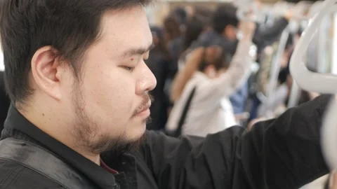 Asian man while handgrip hand held for safty of passenger inside train subw.. 스톡 동영상 335584481