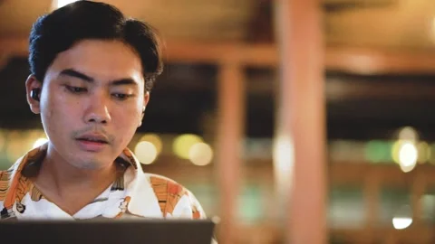 Asian man worker having video call on laptop computer in cafe indoor at night. Stock Footage 289030971