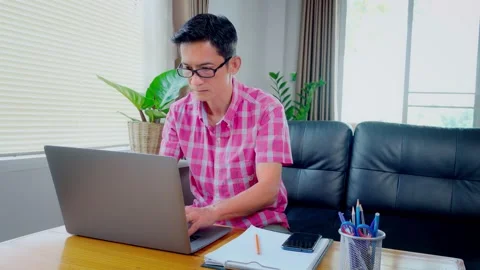 Asian man is working on a laptop device working from home. Are showing disappoin Stock Footage 148089511