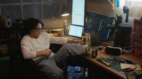 Asian Man Working as Software Developer with Feet on Desk at Night Stock Footage 338421842