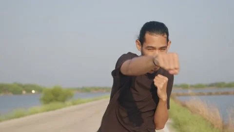 Asian man workout and practice boxing outside on street in countryside Stock Footage 150365657
