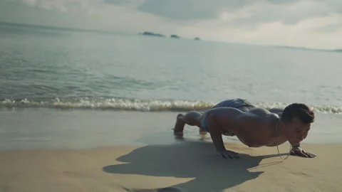 Asian man workout push up exercise in outside beach outdoor fitness training peo Stock Footage 143483146