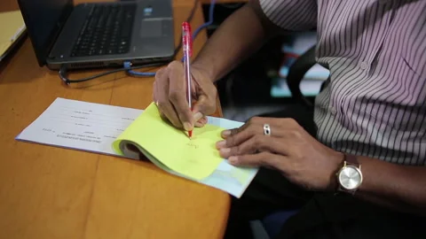 Asian Man Writes in Invoice Book Stock Footage 248798344