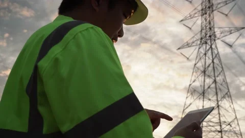 Asian manager engineering electricity high voltage pole with tablet near tower. Stock Footage 175181936