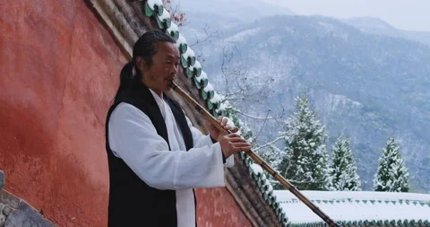 Asian master, demonstrates blowing Chinese bamboo flute in Wudang mountain China 库存影片 201093927