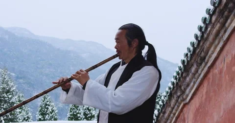 Asian master, demonstrates blowing Chinese bamboo flute in Wudang mountain China Stock Footage 201094702