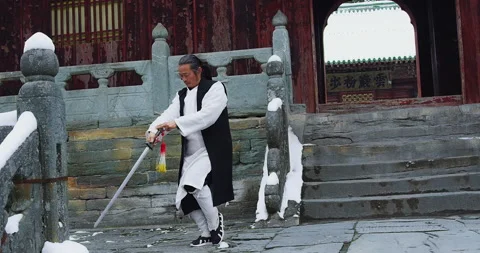 Asian master, demonstrates Tai chi martial arts sword combat in Wudang mountain Stock Footage 201097151