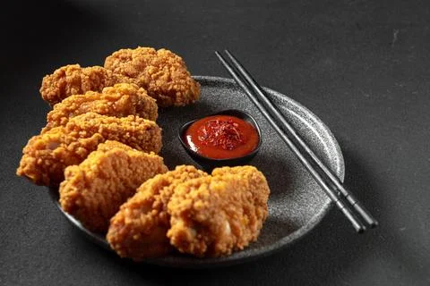 Asian meat deep-fried, breaded in oil in a plate on a dark stone background with Stock Photos