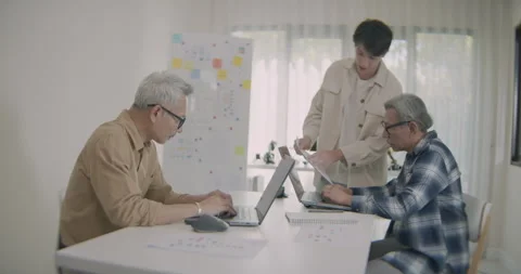 Asian Men Collaborate on Coding Project in Bright Home Office. Stock Footage 308156790