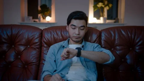 Asian men get tired while watching TV in cozy home at night. Stockbeeldmateriaal 105748880