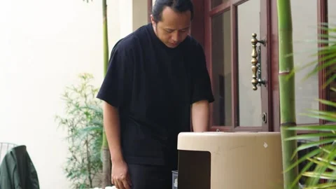 Asian men put out throw cigarette butts unhealthy before entering building Stock Footage 309237930