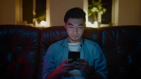 Asian men smiling while chatting with the friends on the smartphone. Stock Footage 105748036