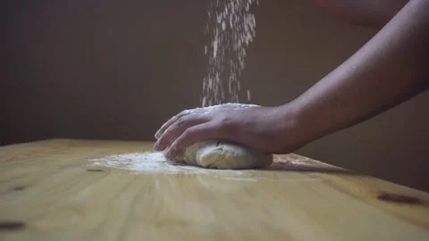 Asian men sprinkle flour over the formed bread dough using their bare hands. Stock Footage 271146465