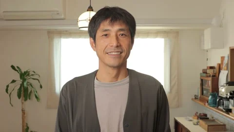 Asian middle aged man smiles at the camera in living room of apartment. 25P. Stock Footage 224899908
