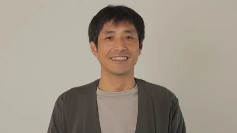 Asian middle aged man smiles at the camera. White background. Stock Footage 224903909
