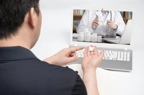 An Asian middle-aged man using a laptop to consult a doctor on telemedicine. Stock Photos