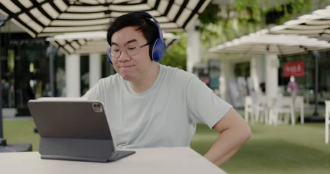Asian middle aged man wearing glasses, headphone to video call Stock Footage 160140772