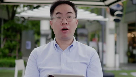 Asian middle aged man wearing glasses, headphone to video call with laptop Stock Footage 161723335
