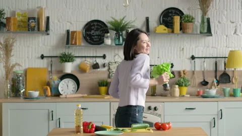 Asian mix race happy young woman enjoying cooking meal at home kitchen, funny Stock Footage 147319659