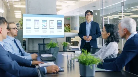 Asian Mobile App Developer Shows Presentation of His New Application Design Stock Footage 83767933