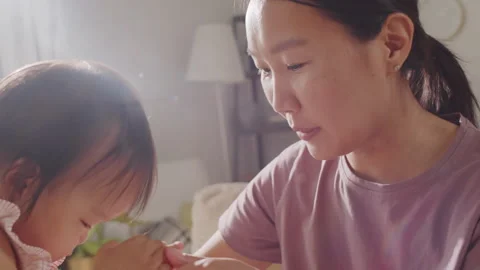 Asian Mom Feeding Cute Daughter with Bab... | Stock Video