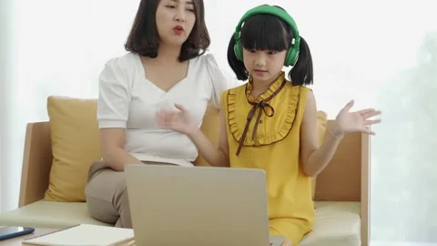 Asian mom teaching kid learning online at home Stock Footage 140425641