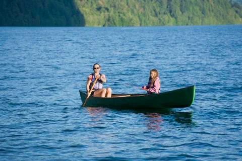 Asian mother and daughter rowing in canoe Stock Photos