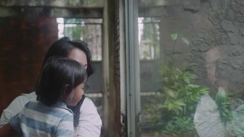 An Asian mother and son look through the... | Stock Video | Pond5