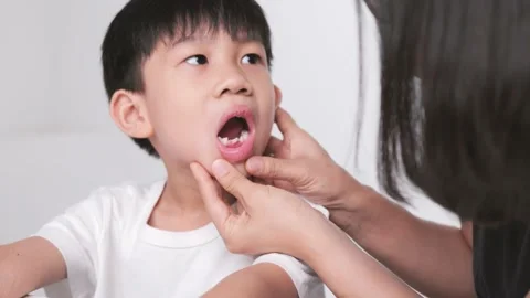 Asian mother checking her son mouth for his dental care. Video stock 197365597