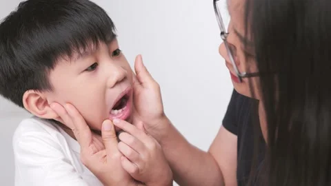 Asian mother checking her son mouth for his dental care. Video stock 202260083