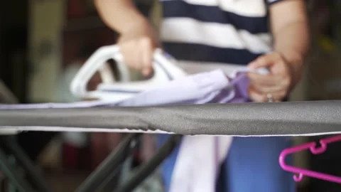 Asian mother laundry and using steam ironing Video stock 134931833