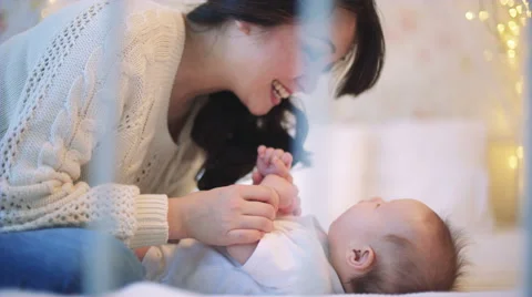 Asian Mother playing with newborn baby Stock Footage